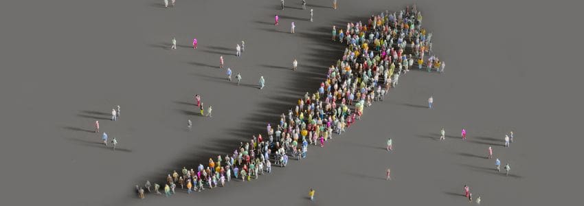 Arial view of employees gathered together forming an upward pointing arrow signifying company growth.