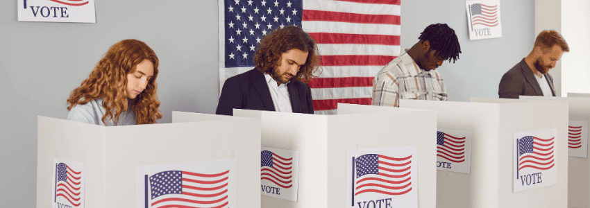 Group of 4 people each standing behind individual voting booths.