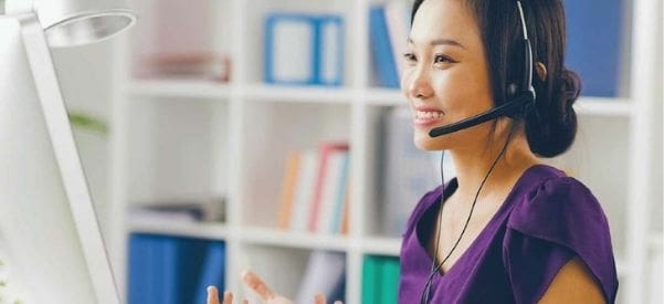 Photo of woman talking on a headset while at her computer, representing our Virtual HR Solutions - part of our Outsourced HR Solutions