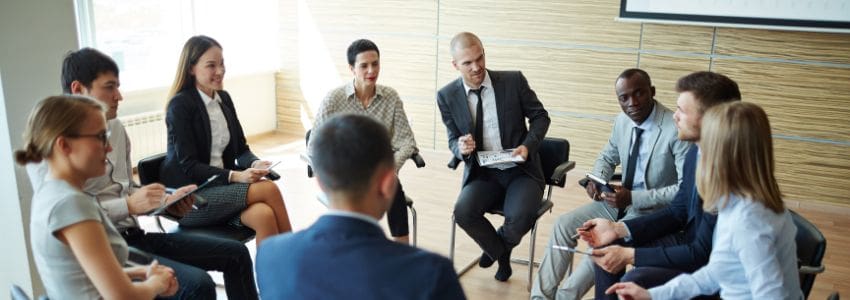 Small discussion group sitting in chairs configured in a circle during new manager training.