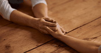 Two arms reaching out to one another to hold hands in empathy